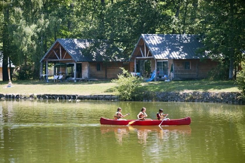 Les cabanes familiales d'Huttopia Rillé et le lac